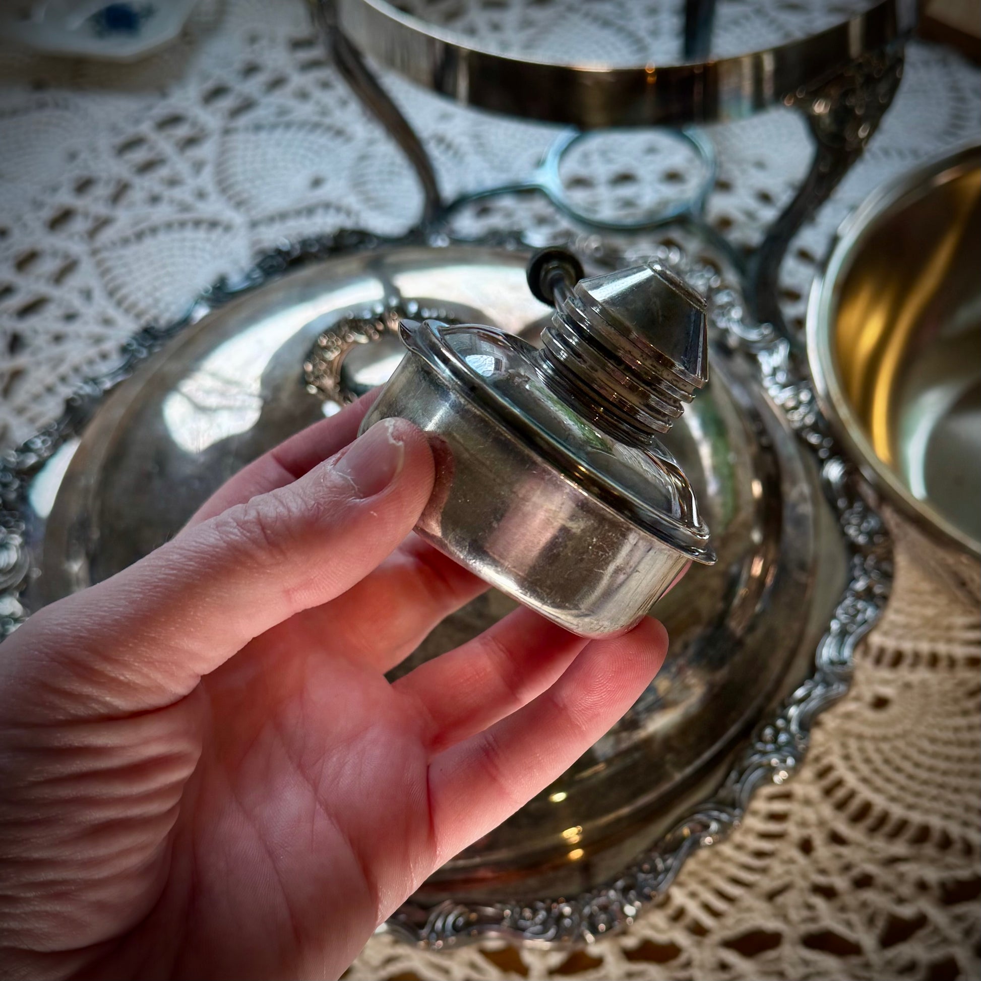 A vintage oil canister being held over a chafing dish