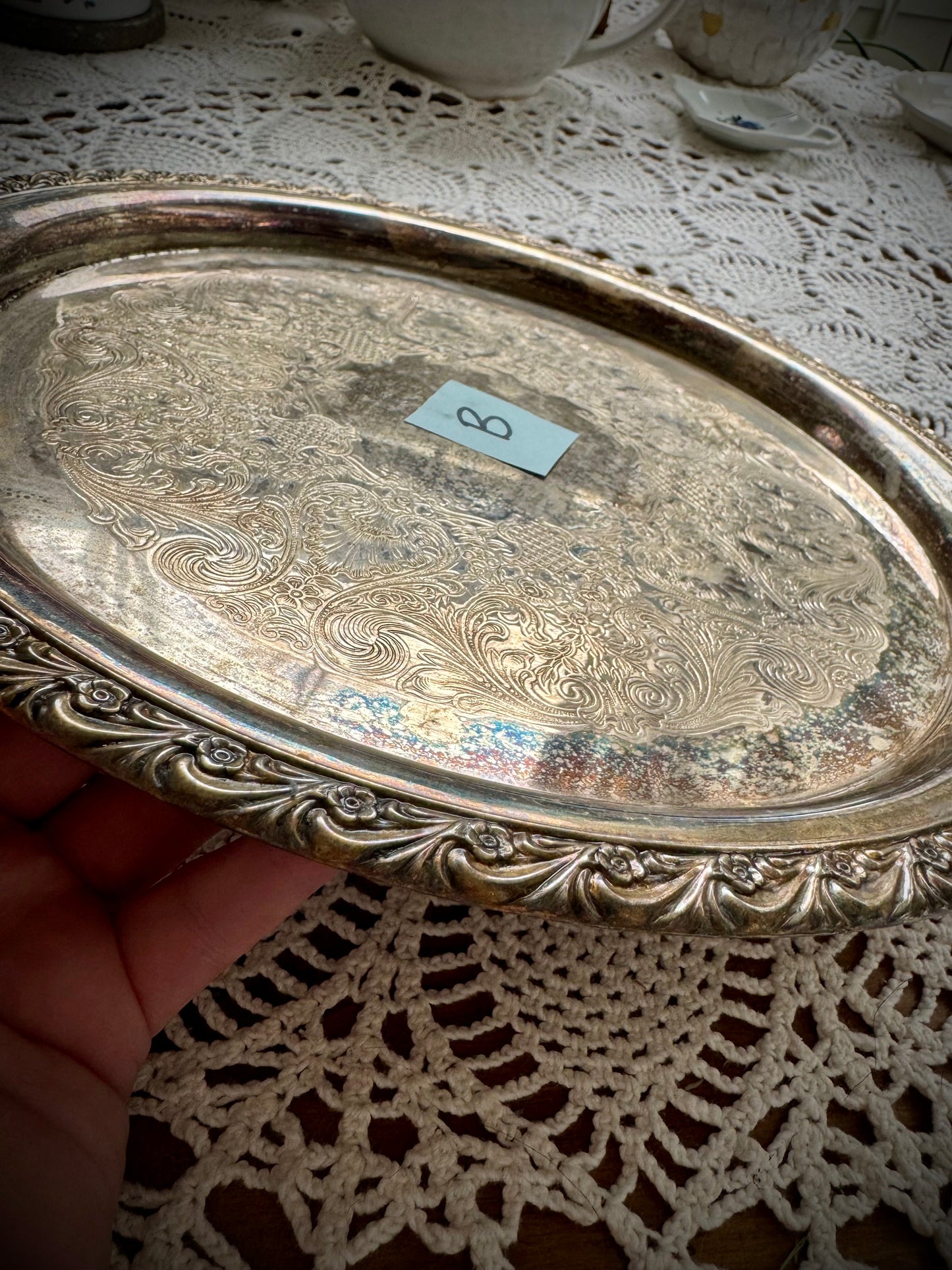 A silverplate round offering tray is displayed on a white lace surface. The tray has a post-it with the letter "B"