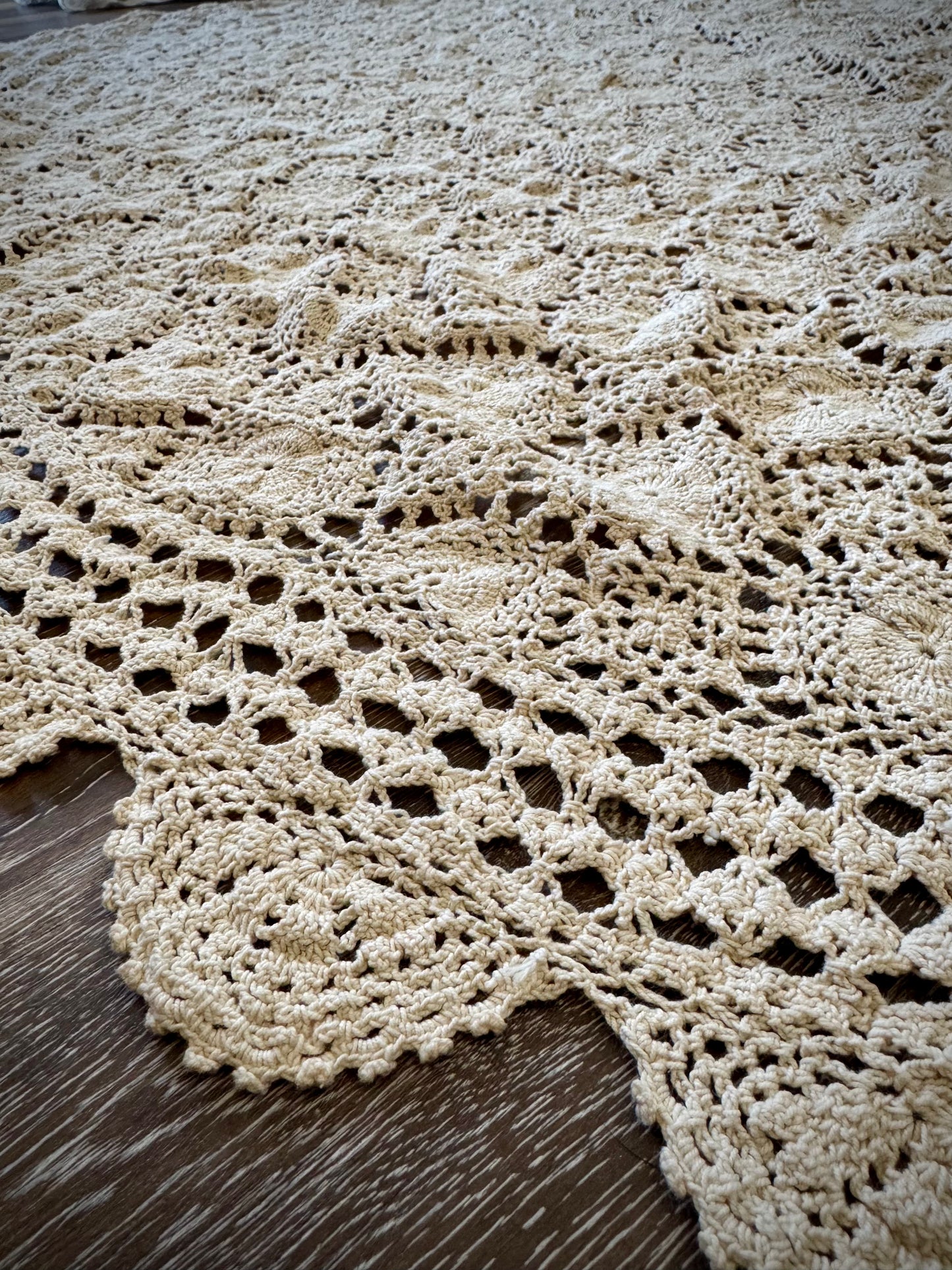 Close up of crochet details on the edge of a vintage ivory tablecloth