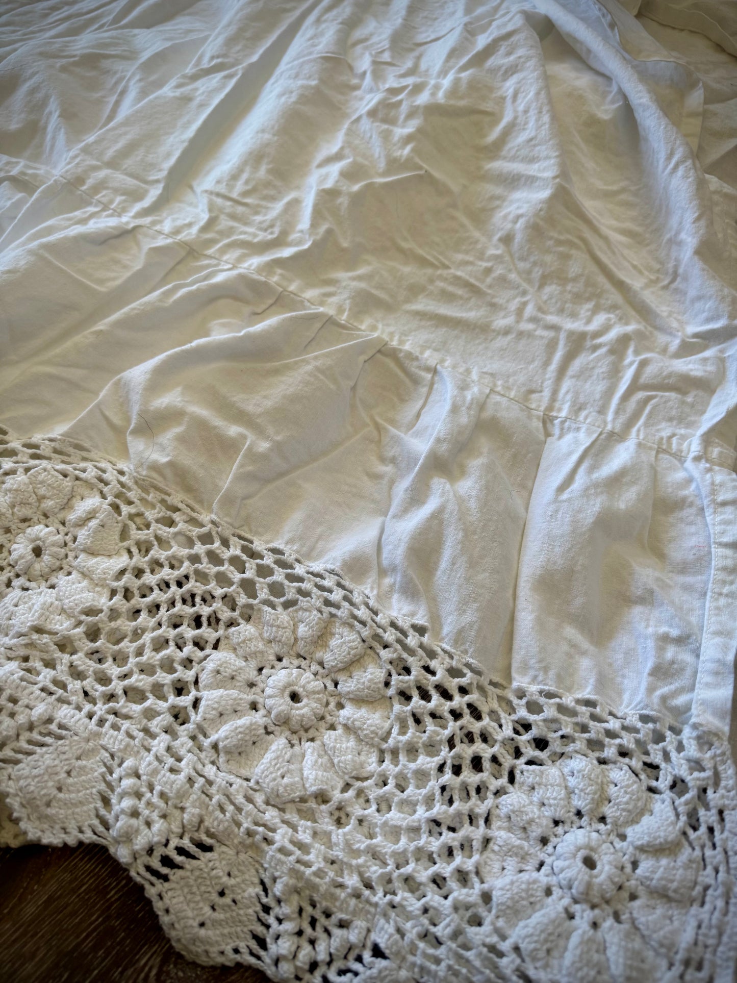 Close up of embroidery details on the edge of a vintage bed skirt