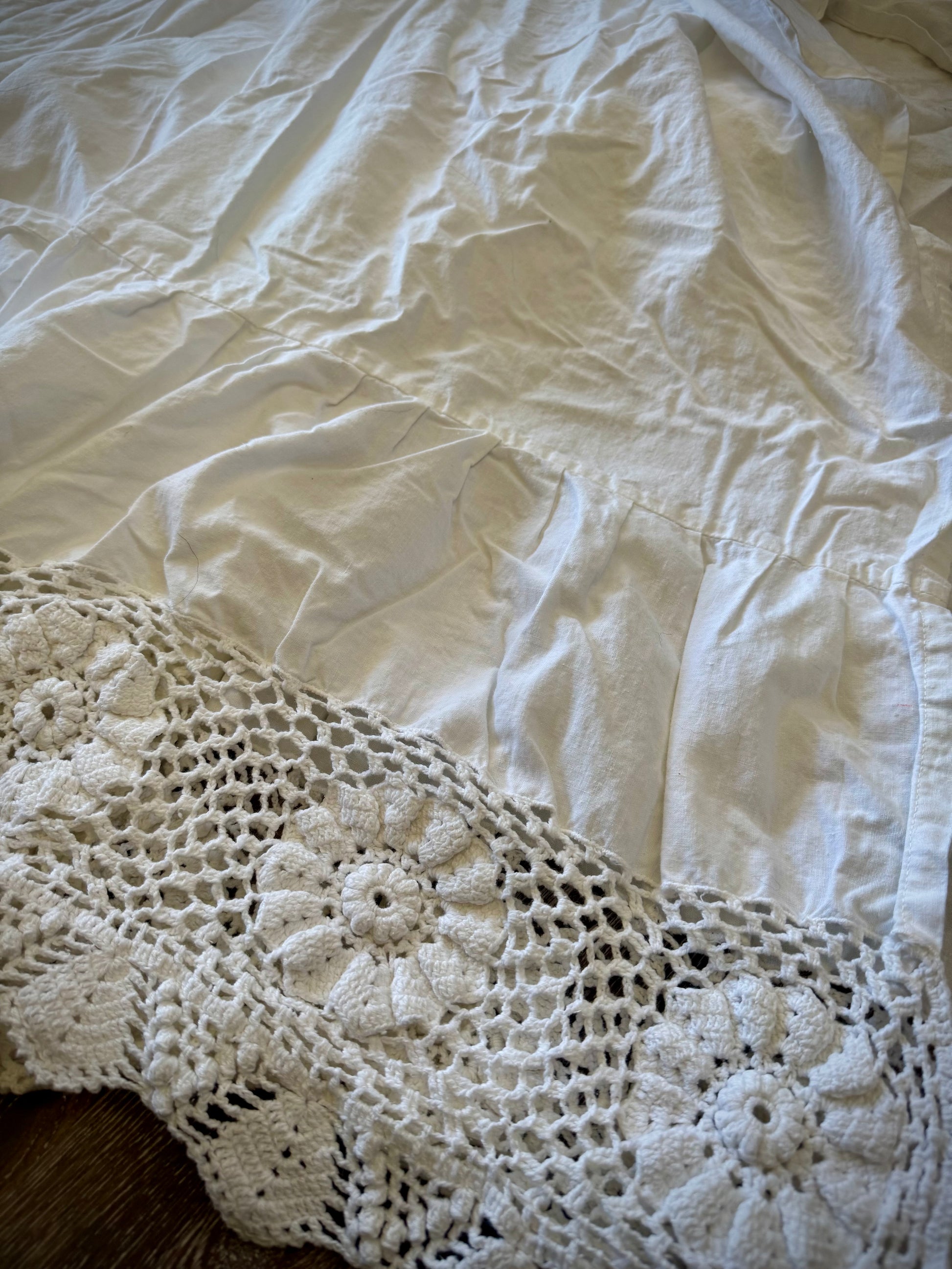 Close up of embroidery details on the edge of a vintage bed skirt